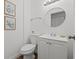 Clean and simple bathroom with white vanity, toilet, and circular mirror at 346 Suwanee Ave, Sarasota, FL 34243