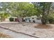 Single-story white home with brown garage door, landscaping, and large trees at 346 Suwanee Ave, Sarasota, FL 34243