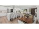 Modern kitchen and dining area with white cabinets, a large island, and a wooden dining table at 346 Suwanee Ave, Sarasota, FL 34243