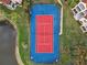 Aerial view of community tennis court with red surface and blue perimeter at 4106 Central Sarasota Pkwy # 1013, Sarasota, FL 34238