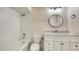 Modern bathroom with white subway tile, updated vanity, and a round mirror at 4304 Camino Madera, Sarasota, FL 34238