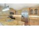 Bright kitchen with ample counter space, stainless steel appliances, and light wood cabinetry at 4304 Camino Madera, Sarasota, FL 34238
