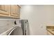 Laundry room with modern washer and dryer and ample cabinet space at 4304 Camino Madera, Sarasota, FL 34238