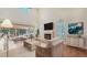 Bright living room with high ceilings, fireplace, and large windows overlooking a patio at 4304 Camino Madera, Sarasota, FL 34238