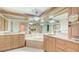 Main bathroom with dual vanity, soaking tub, mirrors, and light wood cabinetry at 4304 Camino Madera, Sarasota, FL 34238
