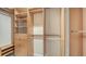 Organized walk-in closet with wooden shelves, drawers, glass-front cabinets, and hanging rods at 4304 Camino Madera, Sarasota, FL 34238