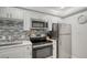 Modern kitchen with stainless steel appliances and white cabinets at 4621 Gulf Of Mexico Dr # 16B, Longboat Key, FL 34228