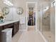 Bright bathroom featuring a glass shower, double vanity, granite counters, and an open walk-in closet at 4925 Surfside Cir, Bradenton, FL 34211