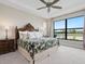 Bright bedroom overlooking a pond, featuring a large window, and a decorative headboard at 4925 Surfside Cir, Bradenton, FL 34211