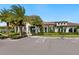 Exterior of community clubhouse, featuring lush landscaping and ample parking at 4925 Surfside Cir, Bradenton, FL 34211