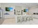 Modern white kitchen with stainless steel appliances, marble countertops, and two flat screen TVs at 4925 Surfside Cir, Bradenton, FL 34211