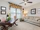 Spacious home office with a desk, couch, ceiling fan, and a window with natural light at 4925 Surfside Cir, Bradenton, FL 34211