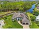 Stunning aerial view of a waterfront house with lush landscaping and a private boat dock on the serene water at 609 Colonial Bay Dr, Nokomis, FL 34275