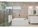 Bright bathroom showcasing soaking tub, tiled shower, and modern vanity at 609 Colonial Bay Dr, Nokomis, FL 34275