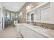 Well-lit bathroom with a modern soaking tub, walk-in shower and marble countertops at 609 Colonial Bay Dr, Nokomis, FL 34275