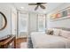 Neutral bedroom featuring wood floors, two windows, and ceiling fan at 609 Colonial Bay Dr, Nokomis, FL 34275