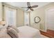 Bedroom with light walls featuring wood floors, ceiling fan, and two large windows at 609 Colonial Bay Dr, Nokomis, FL 34275
