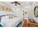 Comfortable bedroom featuring a ceiling fan, hardwood floors, and a decorative area rug at 609 Colonial Bay Dr, Nokomis, FL 34275