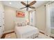 Bedroom with light walls featuring wood floors, ceiling fan, and large window at 609 Colonial Bay Dr, Nokomis, FL 34275