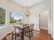 Casual dining area with views of the pool and lake through a large window at 609 Colonial Bay Dr, Nokomis, FL 34275
