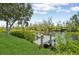 Picturesque waterfront view of the private dock with serene water, surrounded by lush greenery at 609 Colonial Bay Dr, Nokomis, FL 34275