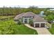 Beautiful waterfront home with lush landscaping, brick driveway, and a charming entrance with double garage at 609 Colonial Bay Dr, Nokomis, FL 34275