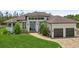 Charming home with a well-manicured lawn, brick driveway, and a welcoming entrance with a double garage at 609 Colonial Bay Dr, Nokomis, FL 34275