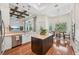 Open kitchen with hardwood floors, island, and view into the breakfast nook at 609 Colonial Bay Dr, Nokomis, FL 34275