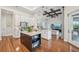 Open kitchen with a central island, white cabinets, and a seamless flow into the living space at 609 Colonial Bay Dr, Nokomis, FL 34275