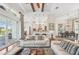 Bright living room with hardwood floors, opening to a white kitchen and dining area with sliding glass doors at 609 Colonial Bay Dr, Nokomis, FL 34275