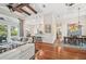 Bright living room with hardwood floors, opening to a white kitchen and dining area, plus access to the lanai at 609 Colonial Bay Dr, Nokomis, FL 34275