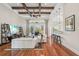 Stylish living room with hardwood floors, beamed ceiling, sliding glass doors, and a breakfast bar to the kitchen at 609 Colonial Bay Dr, Nokomis, FL 34275
