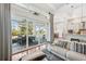 Bright living room with hardwood floors, opening to a white kitchen and dining area, and screened-in lanai beyond at 609 Colonial Bay Dr, Nokomis, FL 34275
