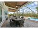 Outdoor dining area with ceiling fans, grill, beautiful views and access to screened-in pool at 609 Colonial Bay Dr, Nokomis, FL 34275