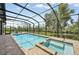 Screened-in pool and spa with lush landscaping and waterfront views at 609 Colonial Bay Dr, Nokomis, FL 34275