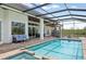 Covered patio with dining and outdoor seating next to a long, screened-in pool and spa at 609 Colonial Bay Dr, Nokomis, FL 34275