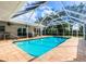 Inviting pool area with screened enclosure, patio, and lush landscaping at 7331 Biltmore Dr, Sarasota, FL 34231