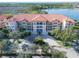 Building showcasing Spanish-style architecture by lake at 7702 Lake Vista Ct # 306, Lakewood Ranch, FL 34202