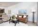 Spacious living room featuring a leather sofa, coffee table, and ample natural light at 7702 Lake Vista Ct # 306, Lakewood Ranch, FL 34202