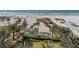 Aerial view of beach with umbrellas, palm trees, and a volleyball court at 915 Seaside Dr # 613 Weeks 4-5, Sarasota, FL 34242