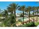Inviting pool area with lounge chairs, umbrellas, and palm trees, overlooking the beach at 915 Seaside Dr # 613 Weeks 4-5, Sarasota, FL 34242