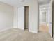 A carpeted bedroom with a closet and entry to a hallway at 9153 Radiant Cir, Sarasota, FL 34241