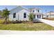 The beautiful two-story home has a grey exterior and front yard with landscaping, grass, and a long driveway at 9153 Radiant Cir, Sarasota, FL 34241