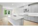 Gourmet kitchen with white cabinets, quartz countertops, stainless steel appliances, and hardwood flooring at 9153 Radiant Cir, Sarasota, FL 34241