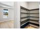 Walk-in pantry with wood shelving, light hardwood flooring, and an exterior view from the adjacent room at 9153 Radiant Cir, Sarasota, FL 34241