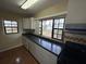 Kitchen with dark countertops, white cabinets, and window views at 1416 26Th W St, Bradenton, FL 34205