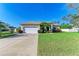 Single-story house with a two-car garage, lush lawn, and mature landscaping at 1605 21St W Ave, Palmetto, FL 34221