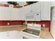 White kitchen cabinets and countertops with a built-in microwave and electric range at 1605 21St W Ave, Palmetto, FL 34221