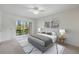 This bedroom offers a relaxing view through large windows, complemented by a ceiling fan at 207 Rubens Dr # D, Nokomis, FL 34275