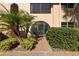 Inviting condo entrance with well-maintained landscaping and a charming arched entryway with a screen door at 207 Rubens Dr # D, Nokomis, FL 34275